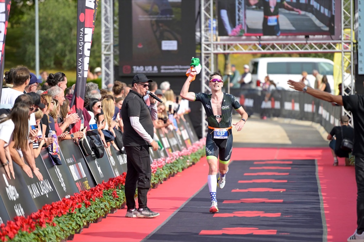 Ed finishing an Ironman 70.3 with the Irish flag raised