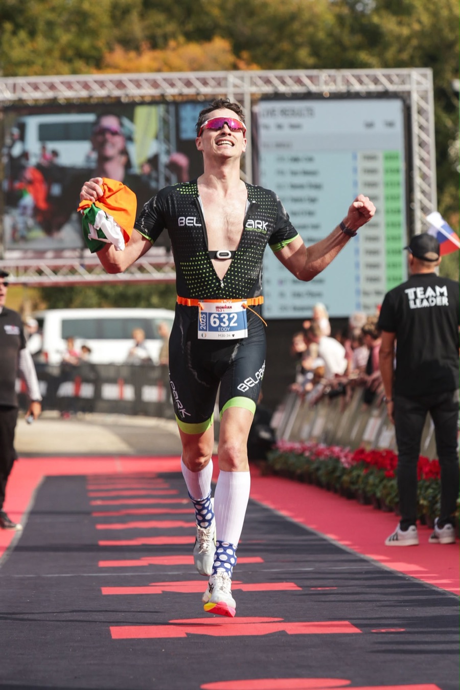Ed celebrating on the Ironman 70.3 finish straight, Irish flag in hand